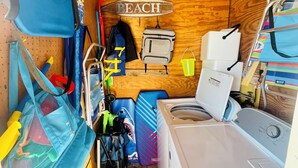 A compact, wooden cabin with a bunk bed, a washing machine, and a small kitchenette. - Sun & Sand condo retreat (Panama City Beach)