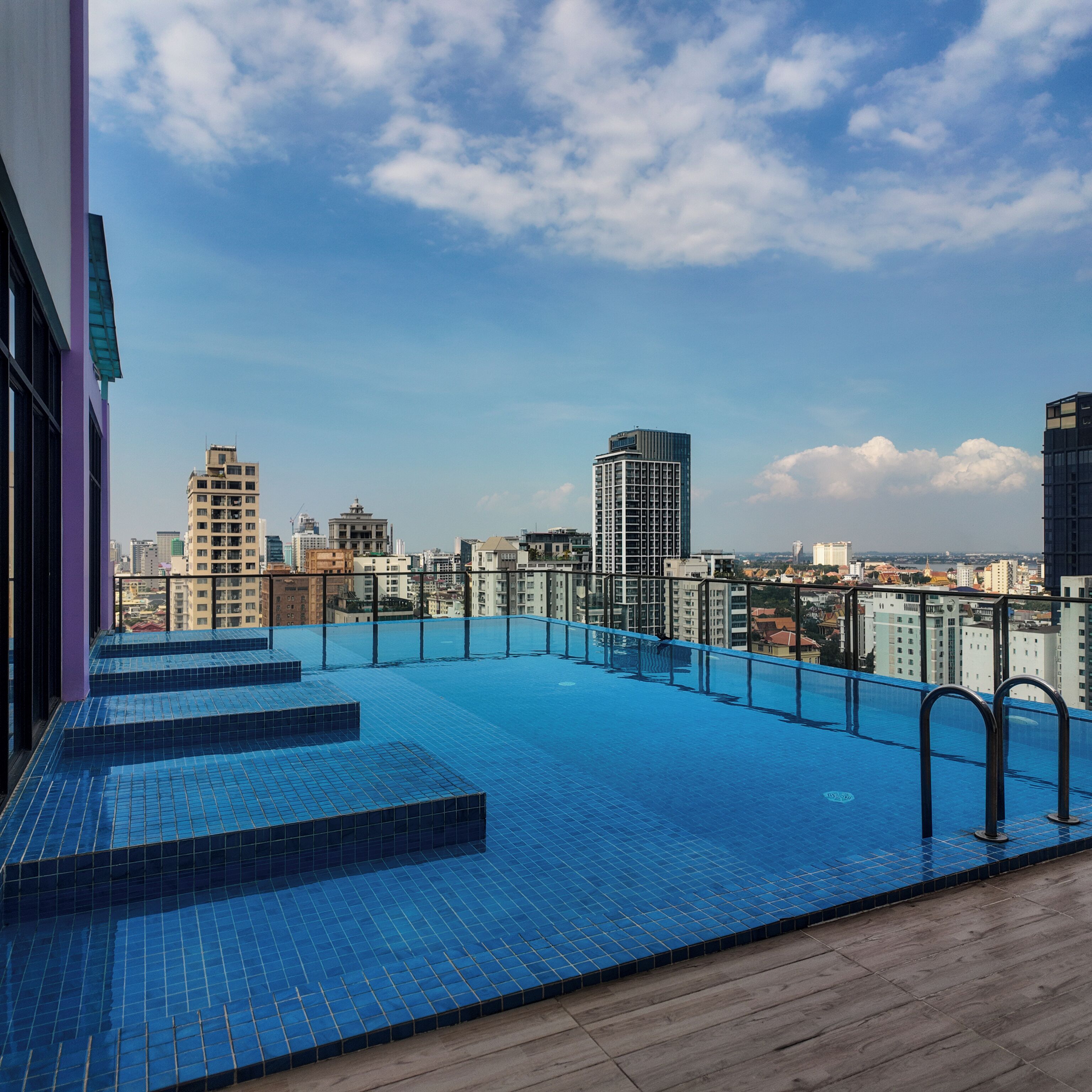 A rooftop pool with a cityscape view, surrounded by buildings.