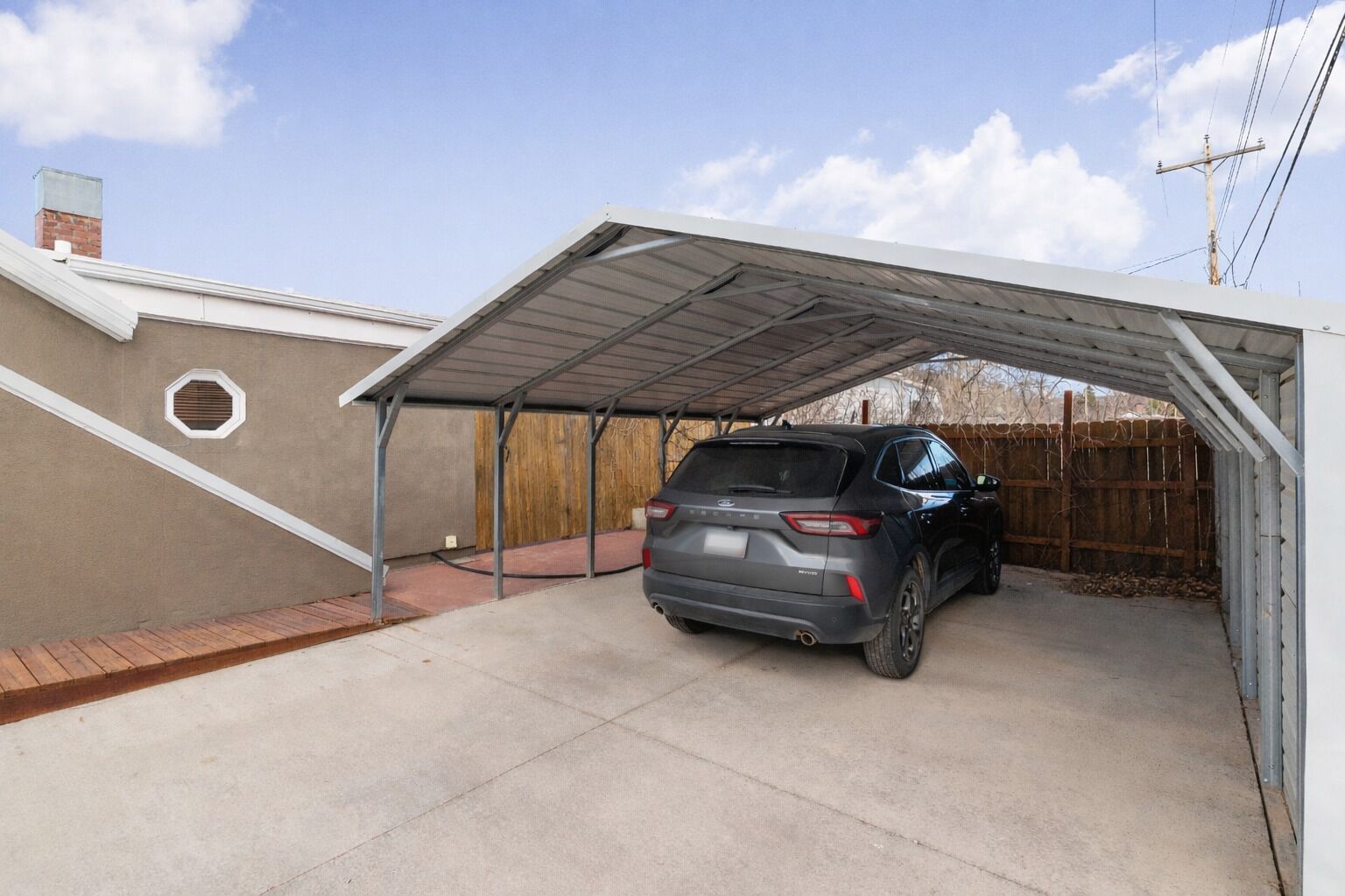 Eine überdachte Garage mit einem geparkten Auto darin.