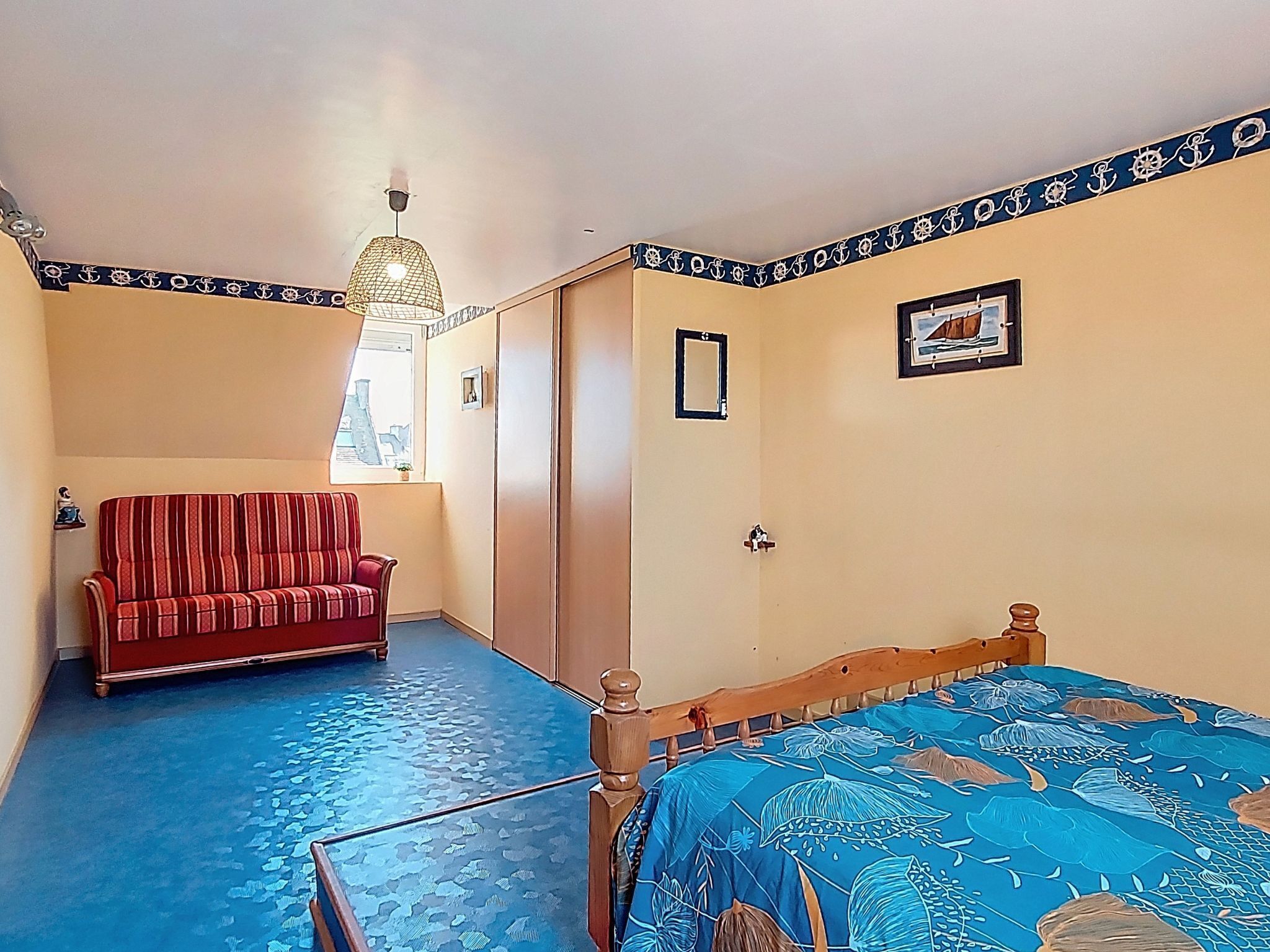 Une chambre à coucher avec un lit, un canapé, une fenêtre et une porte.