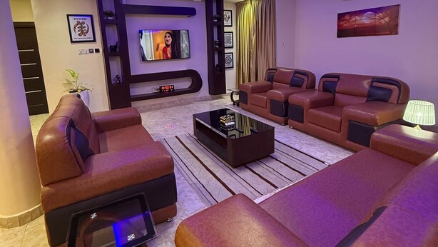 Een moderne woonkamer met leren banken, een salontafel en een flatscreen televisie.