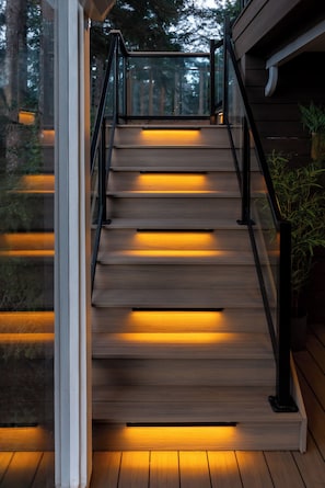 Una escalera de madera con barandillas negras que conduce a un nivel superior.