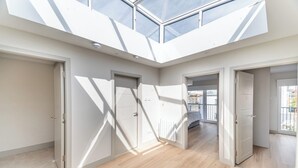 A spacious interior with a high ceiling and skylights, featuring multiple doors and a central open area. - Montague Street (Dublin)