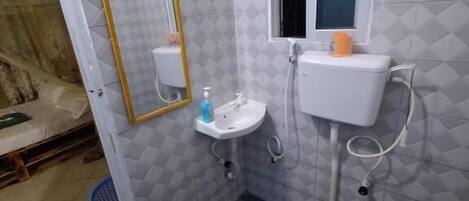 A compact bathroom with a toilet, sink, and window.