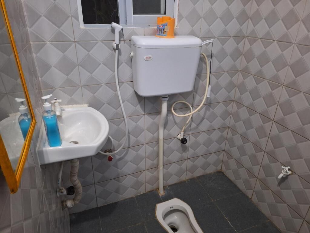 A small bathroom with a toilet, sink, and a window.