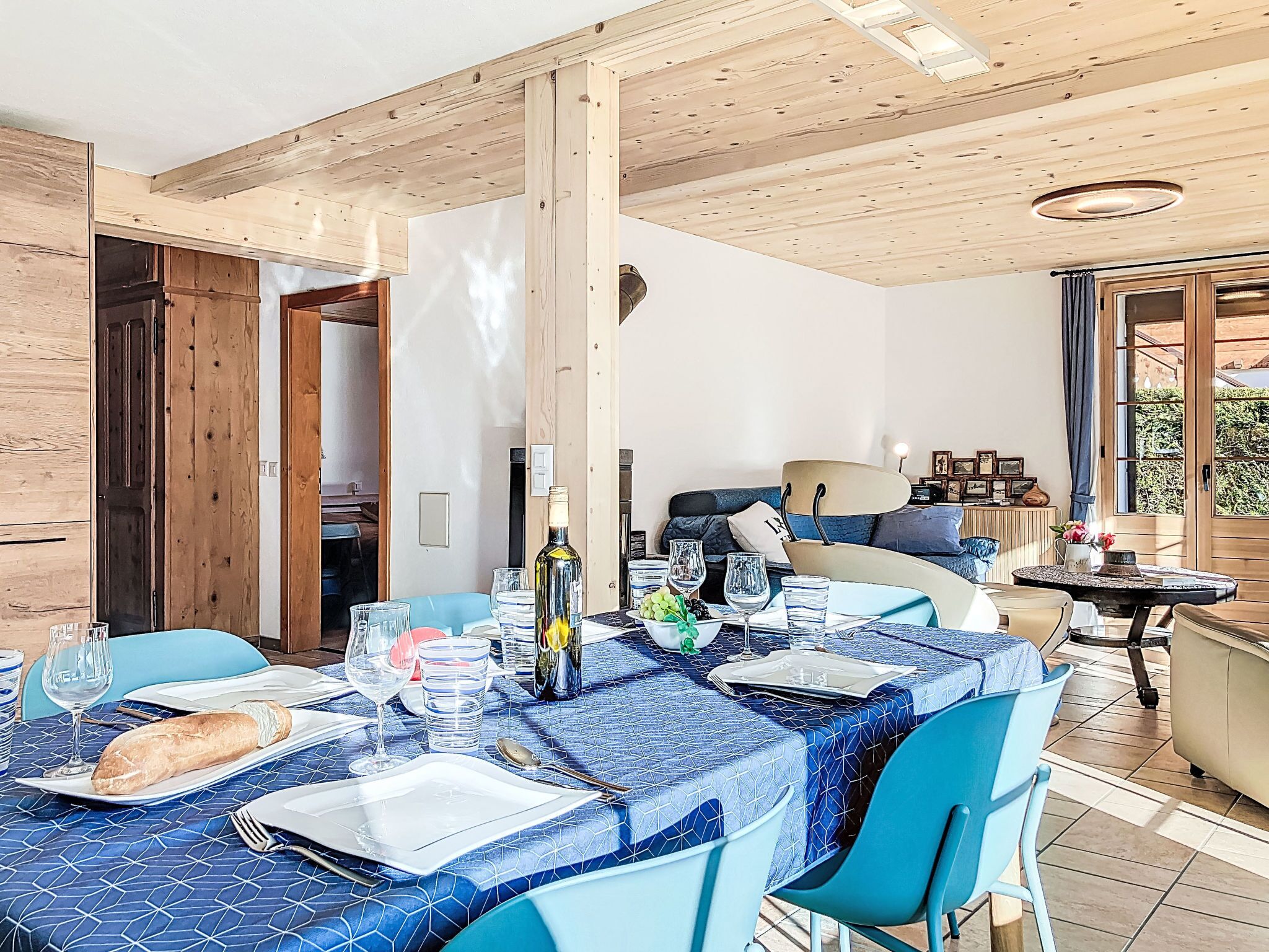 Ein Essbereich mit Tisch für zwei Personen, mit blau gemustertem Tischläufer, Stühlen und verschiedenen Geschirrteilen.