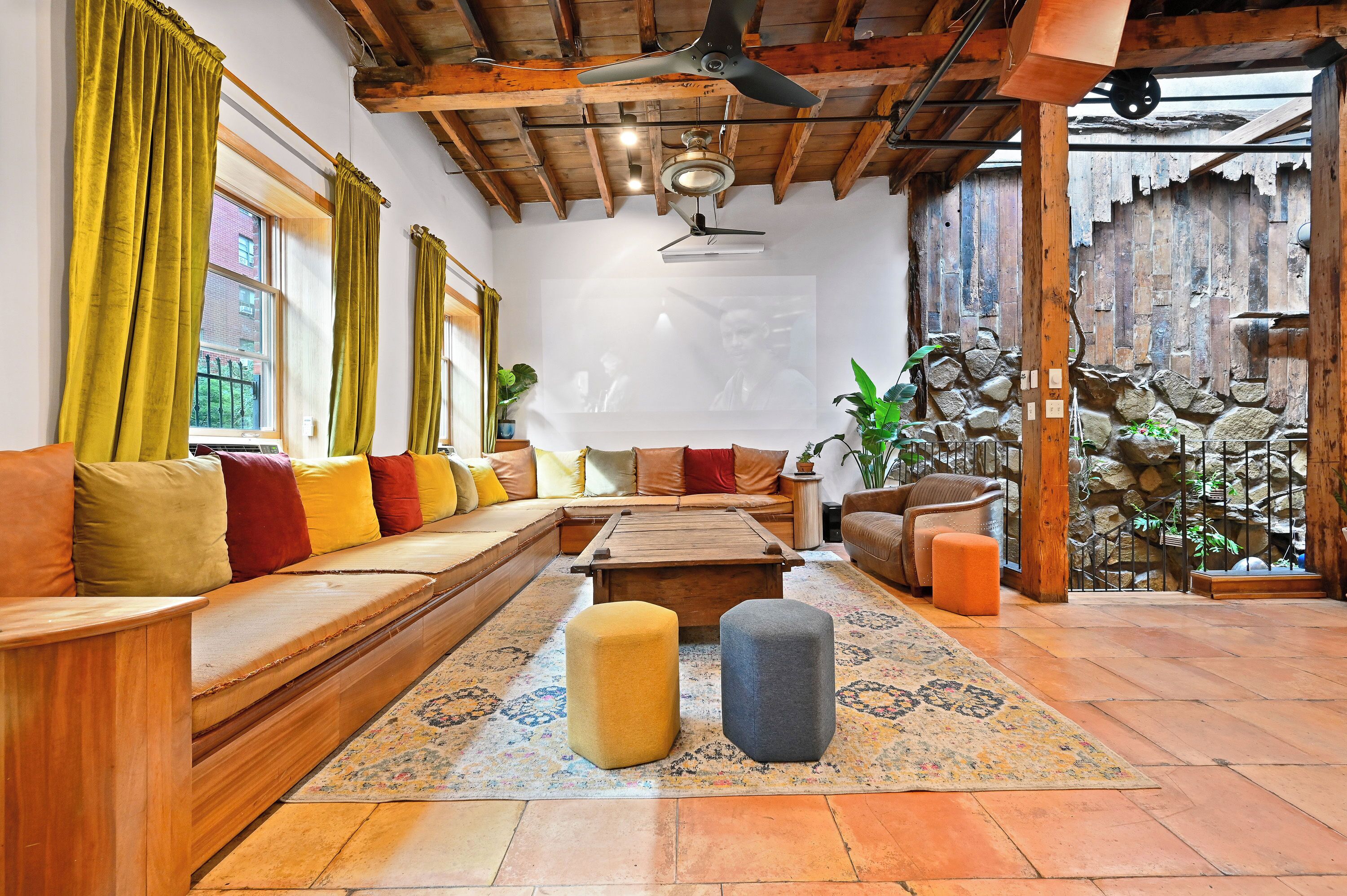 Un salon chaleureux avec un banc en bois, des poufs et une table basse.