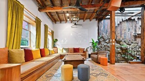 Ein gemütliches Wohnzimmer mit einer Holzbank, Poufs und einem Couchtisch.
