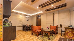 A spacious living area with a wooden floor, a dining table with chairs, and a sofa. - Casa De Himalaya Hotel and Apartment (Kathmandu)