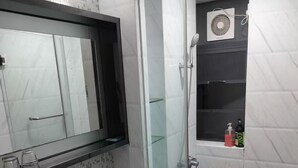 Ein modernes Badezimmer mit Toilette, Waschbecken und einer Duschkabine.