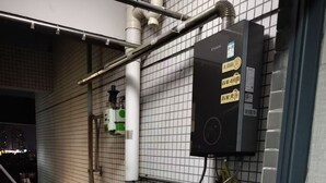 Ein Hauswirtschaftsraum mit Warmwasserbereiter, einer Leiter und einer Wasserfilteranlage.
