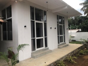 A modern building with large windows and a concrete porch. - Kottamba Resort & Coworker Hostel (Tangalle)