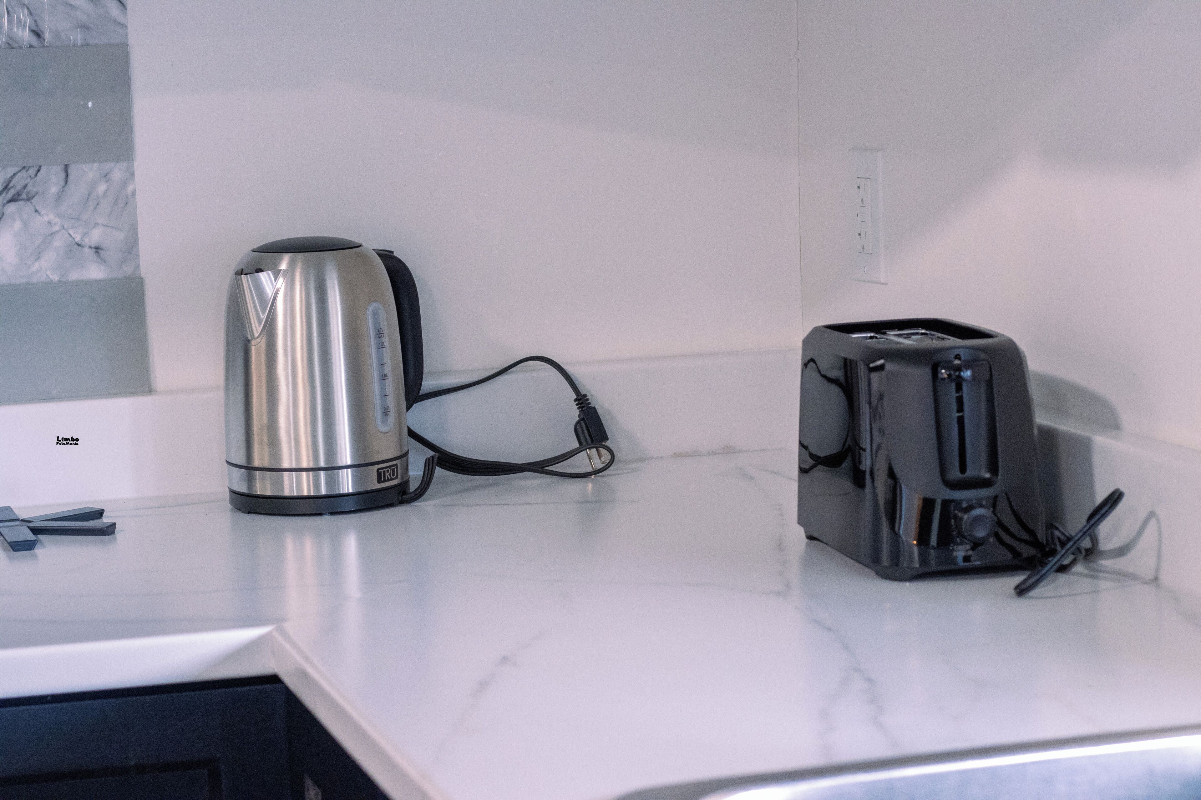 Un piano di lavoro in cucina con un bollitore e un tostapane.