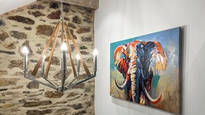 Ein Kronleuchter mit mehreren Leuchten und ein Elefantenbild an der Wand.