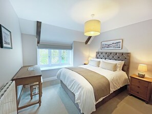 A bedroom with a bed, bedside tables, a desk, a window, and a ceiling light fixture. - The perfect base for exploring, relaxing and making unforgettable memories. (Burton, near Lincoln)