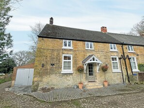 A stone building with a tiled roof, a front door, and two potted plants. - The perfect base for exploring, relaxing and making unforgettable memories. (Burton, near Lincoln)