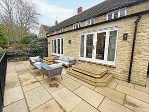 A stone building with a patio area featuring outdoor furniture and a large window. - The perfect base for exploring, relaxing and making unforgettable memories. (Burton, near Lincoln)