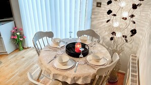 Mesa de comedor dispuesta con platos, cubiertos y un centro de mesa con velas.