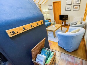 A cozy living room with a blue wall, a television, a sofa, and a coffee table. - 2 bedroom accommodation in Saxmundham (Saxmundham)