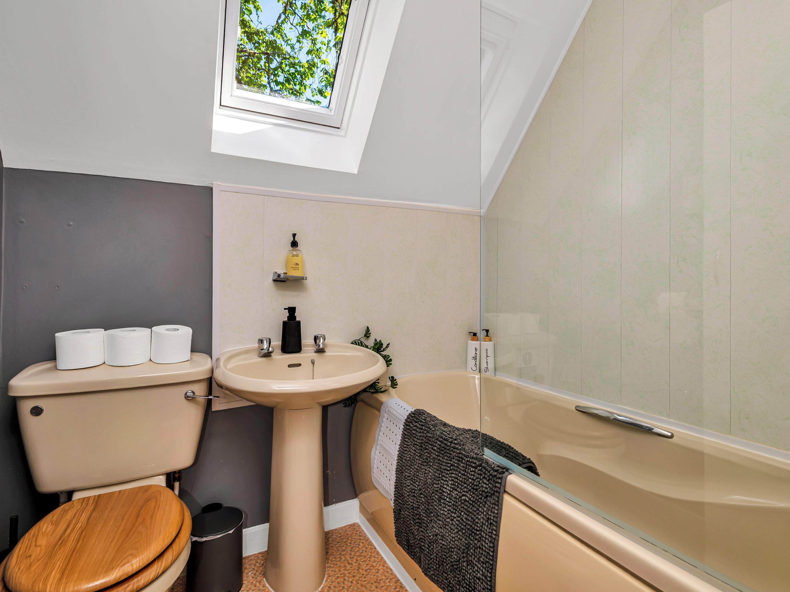 A bathroom with a toilet, sink, and bathtub.