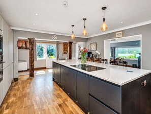 A modern kitchen with a large island, pendant lighting, and a view of the outdoors. - Overscaig House - UK51360 (Lairg)
