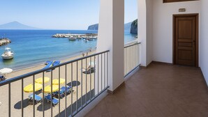 Ein Balkon mit Blick auf das Meer, eine Tür und ein Fliesenboden.