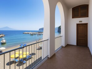 Ein Balkon mit Blick auf das Meer, eine Tür und ein Fliesenboden.