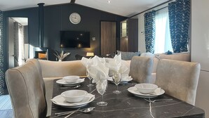 A dining area with a marble table set for four, surrounded by beige upholstered chairs. - Herdwick Lodge - UK51383 (Brocklebank, near Caldbeck and Uldale)