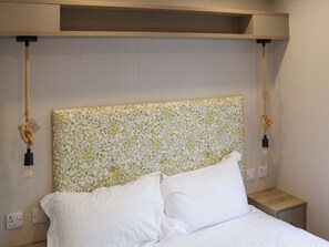 A bed with white bedding, a polka dot headboard, and a wooden nightstand. - 3 bedroom accommodation in Narberth (Narberth)
