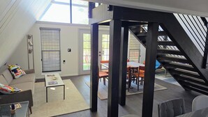 Um interior moderno com escada, área de refeições e um sofá.