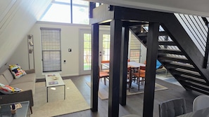 Ein modernes Interieur mit Treppe, Essbereich und einer Couch.
