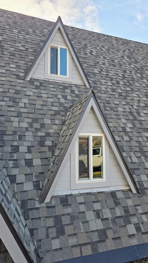 Ein Haus mit einem steilen Satteldach und zwei Dachgauben.