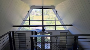 Eine Treppe mit Blick auf eine grüne Landschaft durch große Fenster.