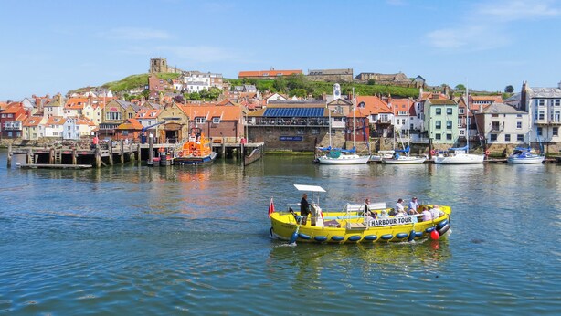 Un port avec des bateaux, un quai et une ville avec des bâtiments.