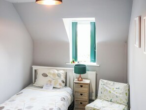 A bedroom with a bed, bedside table, lamp, window, and a chair. - 2 bedroom accommodation in Narberth (Narberth)