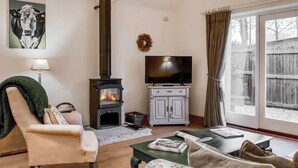 A living room with a fireplace, television, and comfortable seating. - 1 bedroom accommodation in South Barrow, near Yeovil (Yeovil)