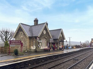 En bygning i sten med et skilt, der siger "Horton in Ribbledale", ved en togstation.