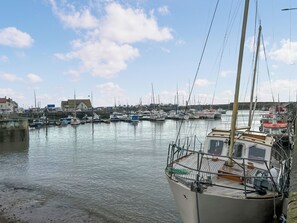 A marina with multiple boats docked, a wooden pier, and buildings in the background. - Elegant, homey Anstruther apartment with sea views and fresh coastal air. (Anstruther)