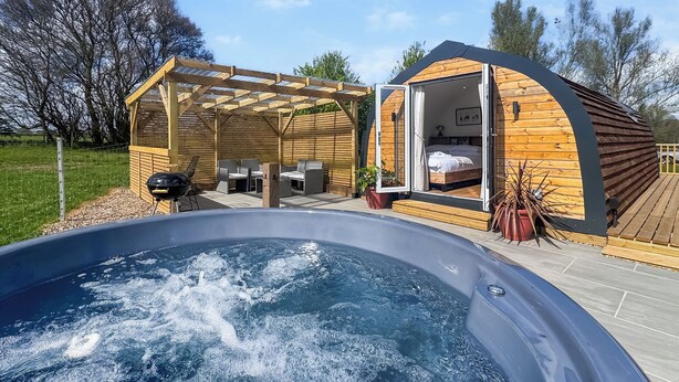 Un bain à remous, une terrasse en bois et une chambre avec fenêtre.