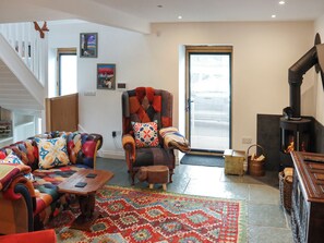 Un salon avec un canapé, un fauteuil et une cheminée.