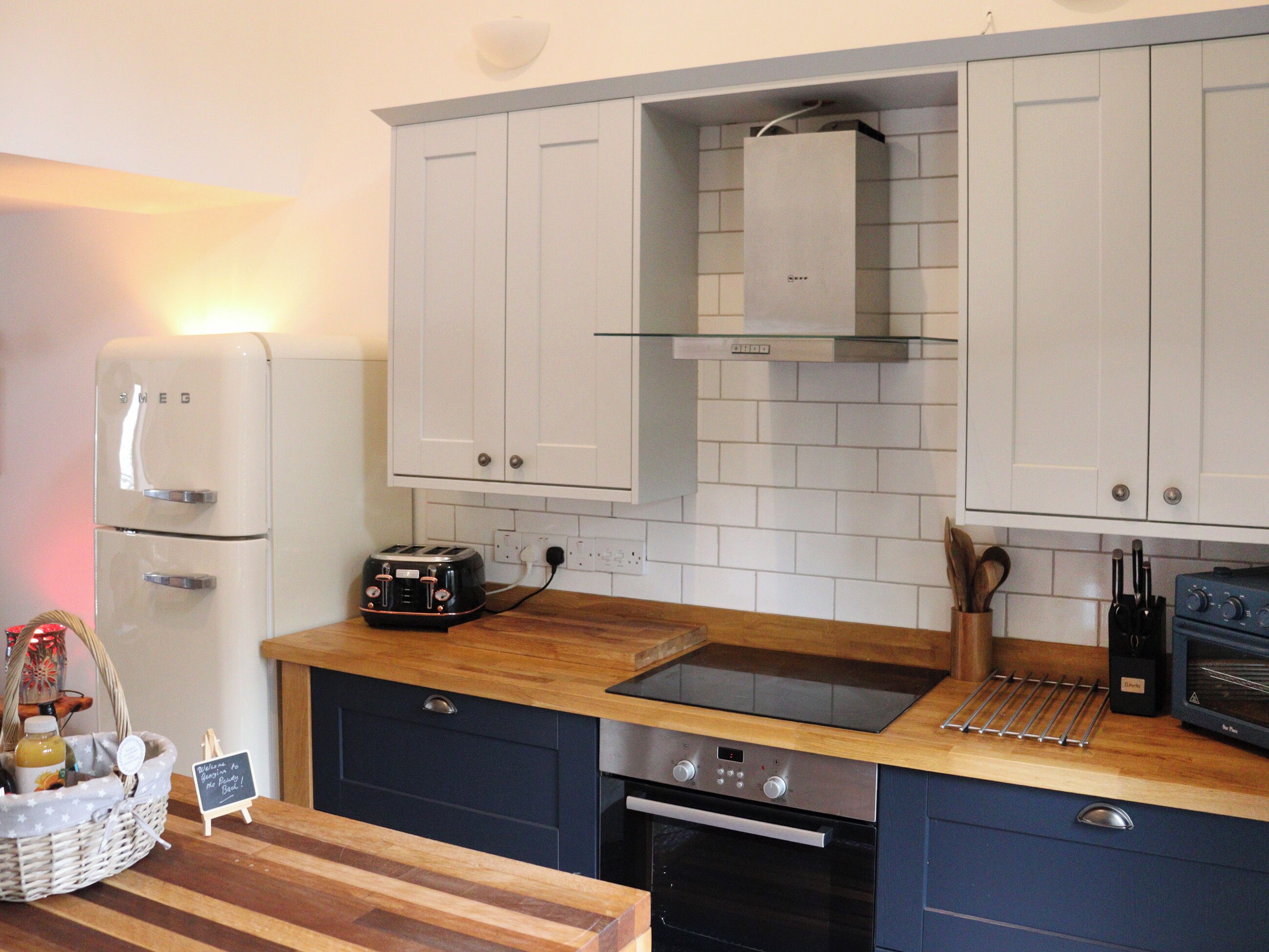 A kitchen with white cabinets, a toaster, a sink, and a stove.