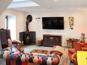 Una sala de estar acogedora con chimenea, un televisor de pantalla plana y un sofá cómodo.