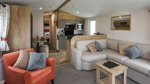 Ein kompakter Wohnbereich mit Sofa, kleinem Tisch, einer Küchenzeile und einer Essecke.