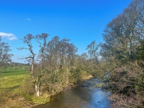 A river flowing through a rural landscape with trees and open fields. - Pet friendly one-bedroom annex, perfect for couples or two friends. (Armathwaite)