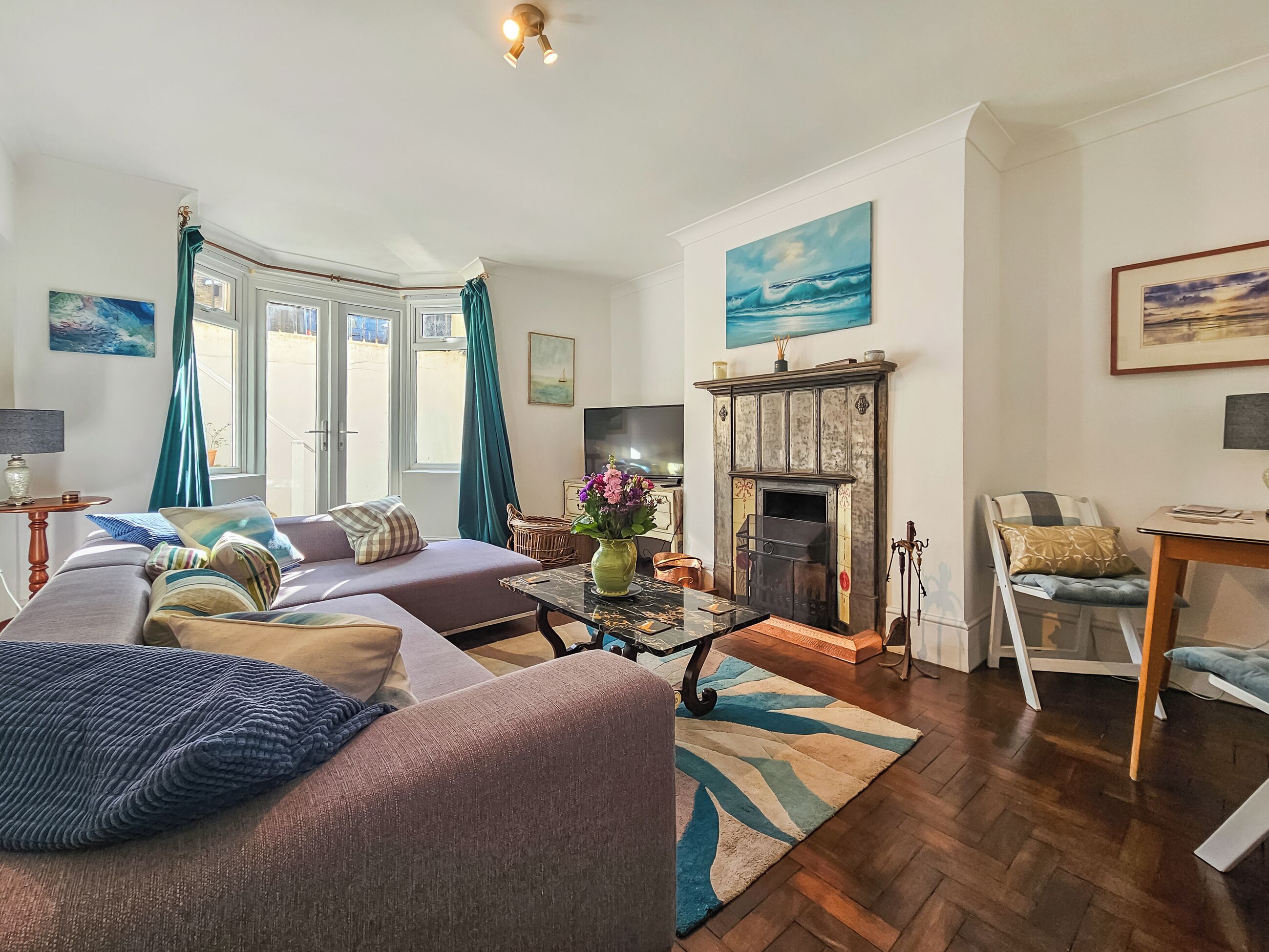 Una sala de estar con sofá, chimenea, mesa y sillón.