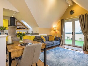 A modern apartment with a kitchen, dining area, and a balcony with a view. - 1 bedroom accommodation in Truro (Truro)