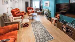 A modern living room with a sofa, armchair, coffee table, and a television. - 3 bedroom accommodation in Ramsgate (Ramsgate)