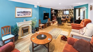 A living room with a fireplace, a television, and a sofa. - 3 bedroom accommodation in Ramsgate (Ramsgate)