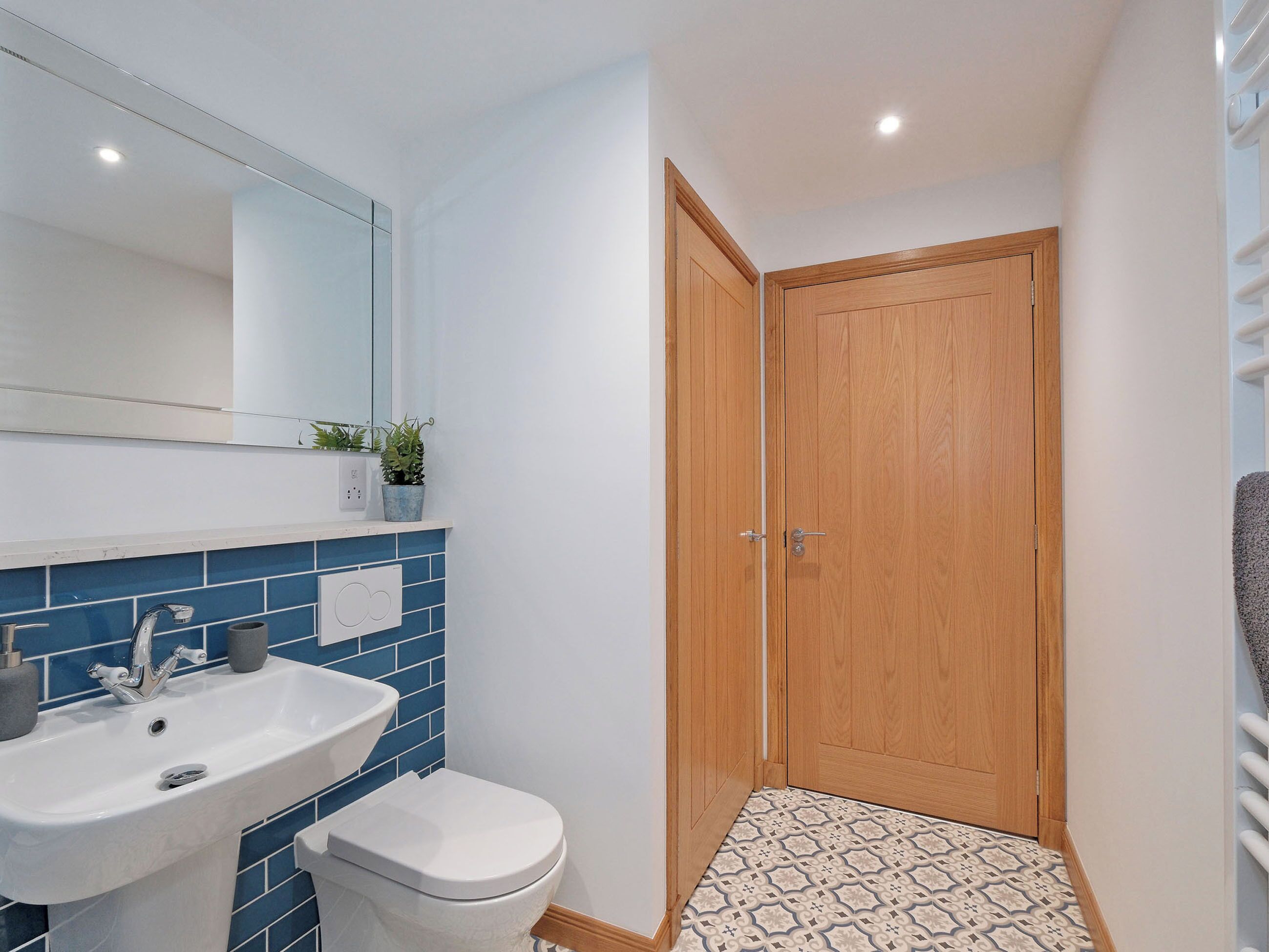 A bathroom with a sink, toilet, and wooden door.