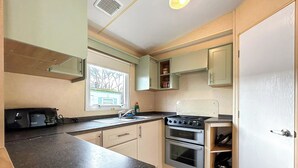 A compact kitchen with a built-in oven, a stove, and a sink.